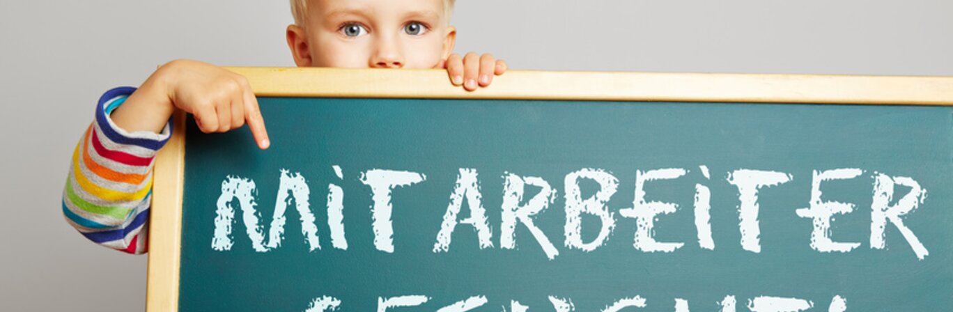 Auf dem Bild ist ein Kind zu sehen, das eine Tafel in der Hand hält mit der Aufschrift "Mitarbeiter gesucht" | © Fotolia - Robert Kneschke